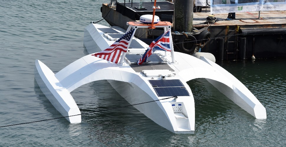 The Mayflower Autonomous Ship in the water at Plymouth Barbican, flying the UK and US flags